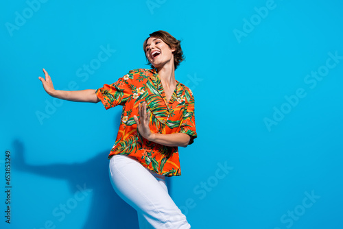 Photo of positive optimistic girl wear trendy outfit having fun chilling enjoying vacation empty space isolated on blue color background