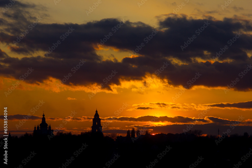 fiery sunset with clouds and silhouette of the cathedral in the foreground