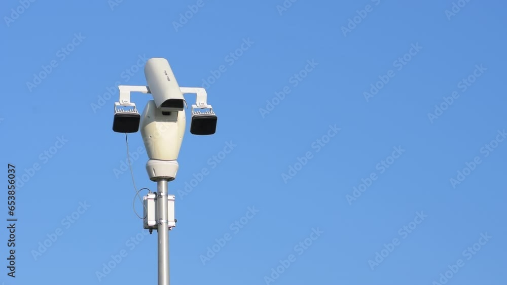 White public camera rotating on background blue clear sky. System, security, secure, rotary, area, spy, scan, cctv, tv, lens, sensor, safety, city, moving, view, real time, close up, hd. ProRes 422HQ. White public camera rotating on background blue clear sky. System, security, secure, rotary, area, spy, scan, cctv, tv, lens, sensor, safety, city, moving, view, real time, close up, hd. ProRes 422HQ.