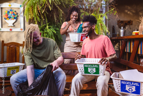 Grupo de diversos voluntarios trabalhando juntos, sorrindo, separando plastico reutilizado para reciclagem de residuos. photo