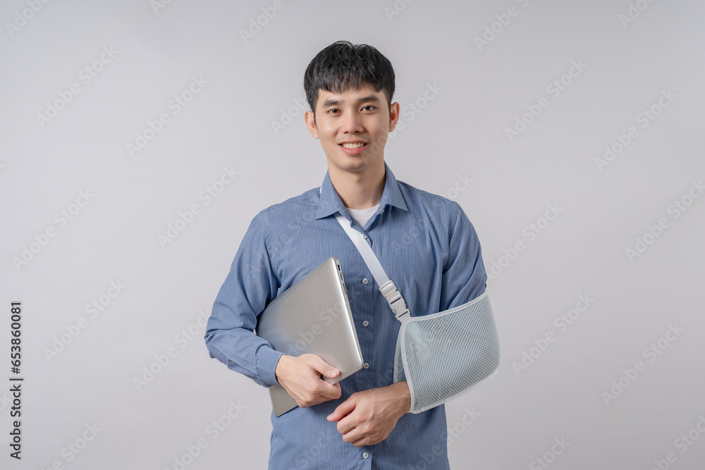 Businessman wears cast on his broken arm after an accident and and holding computer laptop. Businessman wears cast on his broken arm after an accident and and holding computer laptop.