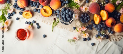 Summer picnic scene with a bowl of delicious fruits wineglasses and wildflower bouquet on a blanket Featuring blueberries peaches and apricots Represents vacation and quality family time