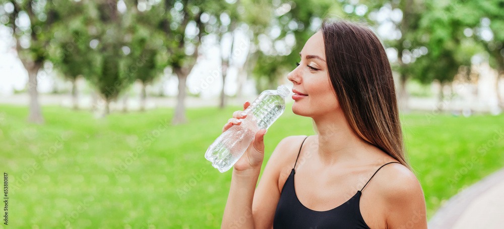 sports girl jogging in the park and drinking water