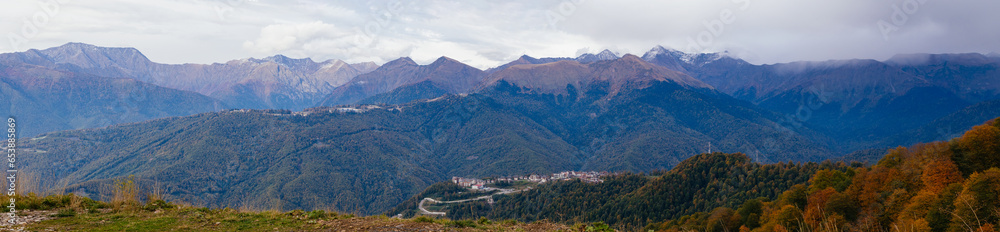 Panorama: view of the Caucasus Mountains in autumn. Clouds over the peaks
