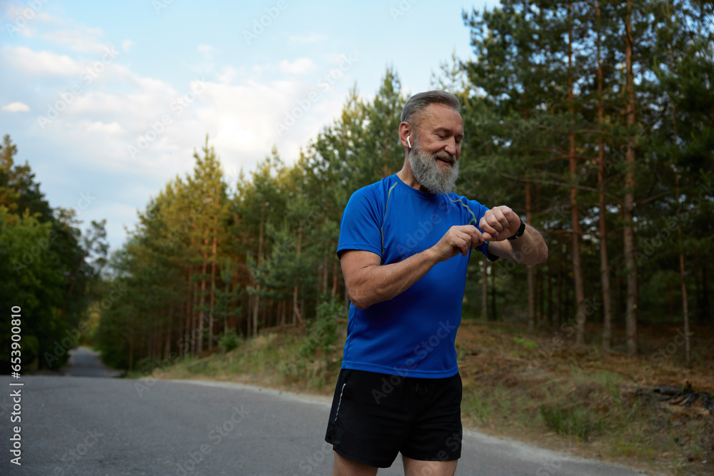Retired sportsman using modern digital gadget during running Retired sportsman using modern digital gadget during running