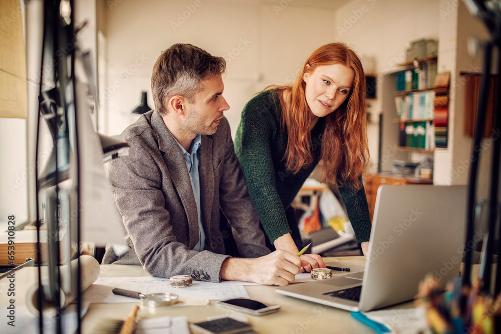 Two diverse colleagues working on a project together in a modern office Two diverse colleagues working on a project together in a modern office