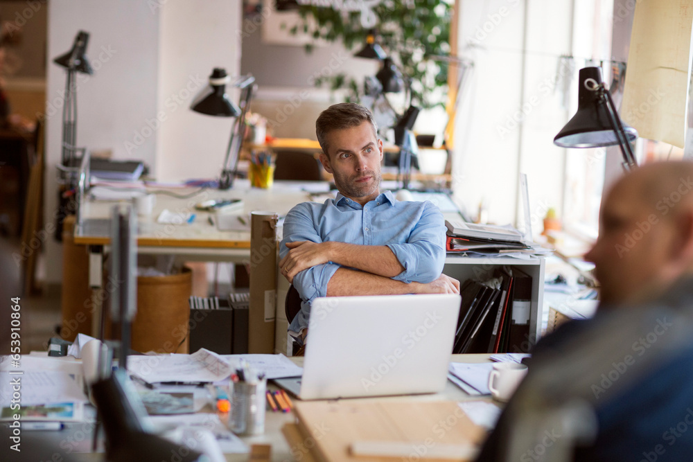 Middle aged Caucasian architect working on building plans in a modern company office Middle aged Caucasian architect working on building plans in a modern company office