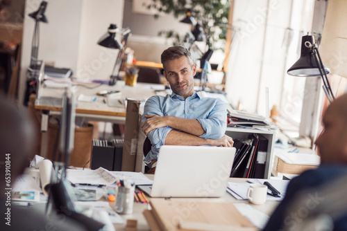 Middle aged Caucasian architect working on building plans in a modern company office