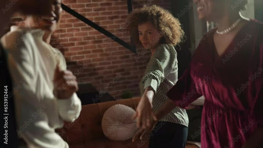 Diverse group of friends dancing together at home