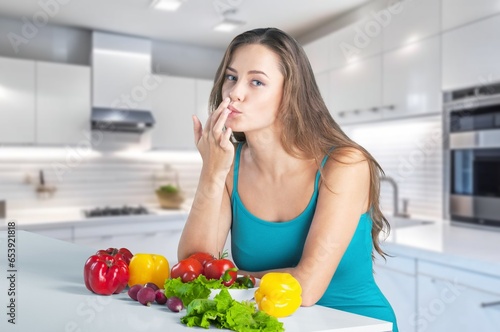 Happy young woman eats fresh vegetables