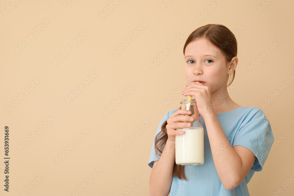 Little girl with bottle of milk on beige background Little girl with bottle of milk on beige background