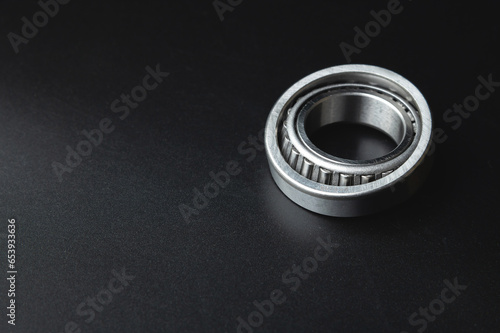 New angular contact roller bearing of a new hub close-up, auto parts on a black background