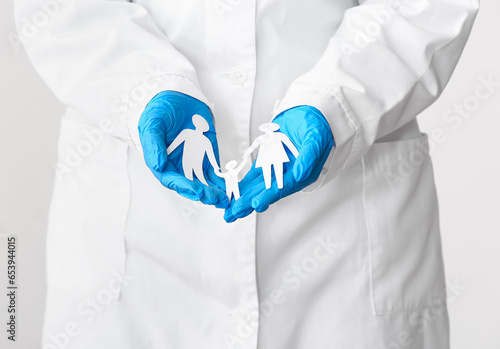 Doctor holding figures of f...