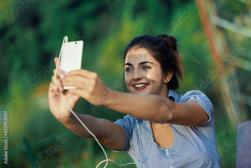 фотографія Young woman uses smartphone for social media engagement