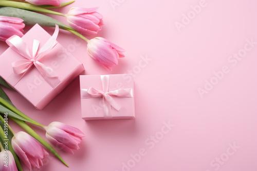 Beautiful arrangement of pink tulips placed alongside pink gift box on pink surface. Expressing love, appreciation, or celebrating special occasions. Floral arrangements, and gift-related designs © vefimov