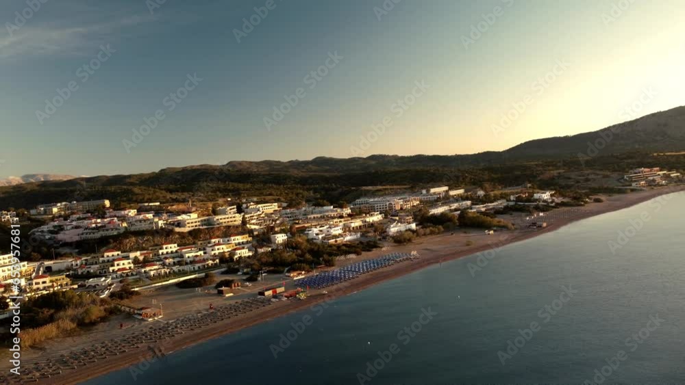 4k Aerial view sunrise over kiotari beach in Rhodes, greece. Smooth cinematic footage. Classic Greek white buildings and blue waters. 4k Aerial view sunrise over kiotari beach in Rhodes, greece. Smooth cinematic footage. Classic Greek white buildings and blue waters.