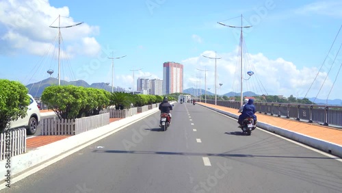 City bridge over the Kai River. Nha Trang city in Vietnam on a sunny day. Video shooting while riding a motorbike. photo