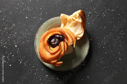 Plate of tasty cruffin with chocolate on black background photo