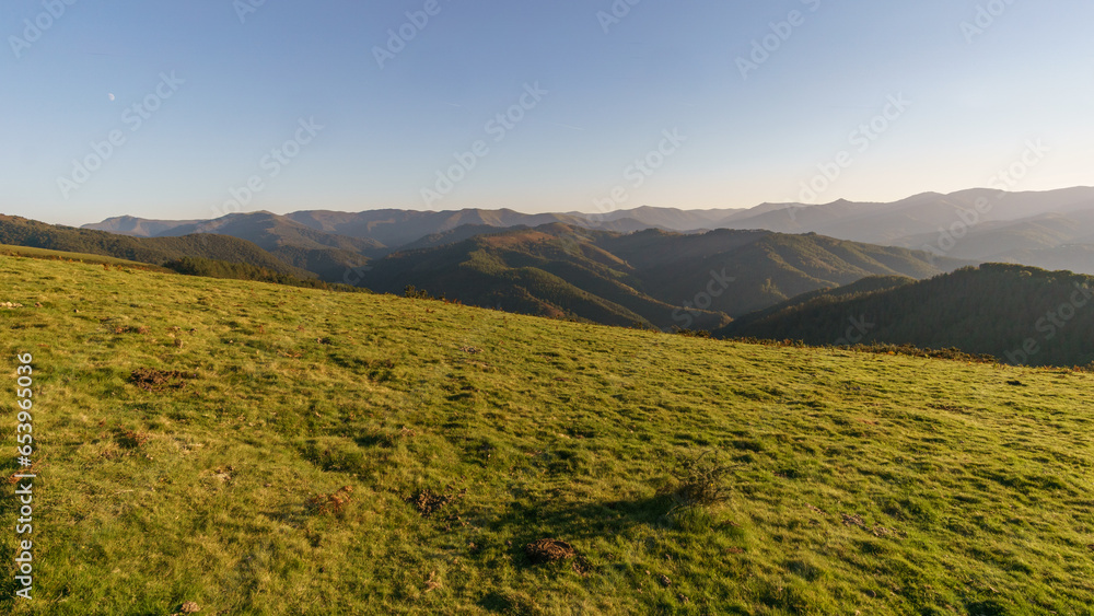 Basque landscape at golden hour during sunset with beautiful hills and meadow in foreground, Aiako Harria, Gipuzkoa, Basque Country, Spain Basque landscape at golden hour during sunset with beautiful hills and meadow in foreground, Aiako Harria, Gipuzkoa, Basque Country, Spain