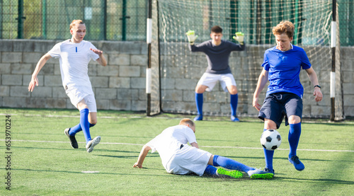 Junior football teams having scrimmage and struggling for ball © JackF