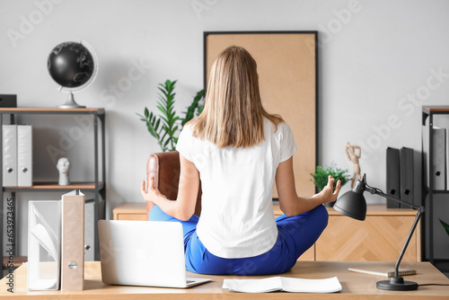 Young businesswoman meditat...