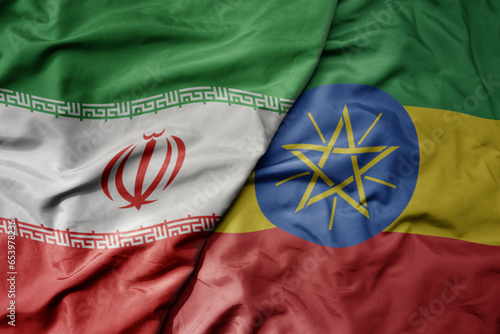 big waving realistic national colorful flag of iran and national flag of ethiopia .