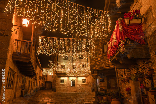 PUEBLA DE SANABRIA, SPAIN - DECEMBER 26, 2022: Beautiful street of the medieval village of Puebla de Sanabria, in Zamora, with the christmas illumination at night. Spain