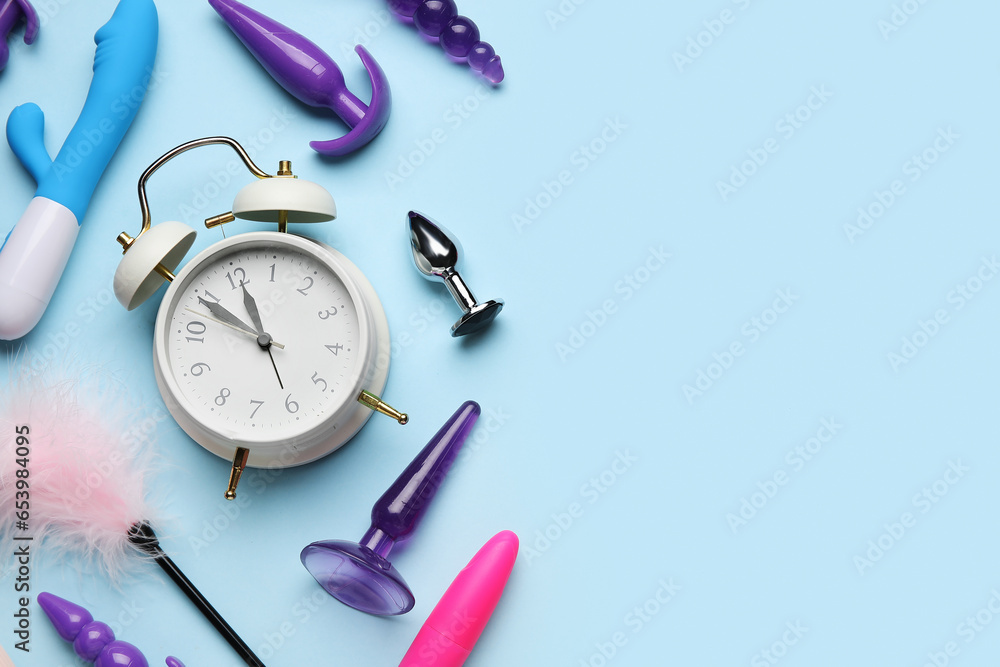 Alarm clock with sex toys on blue background - obrazy, fototapety, plakaty 