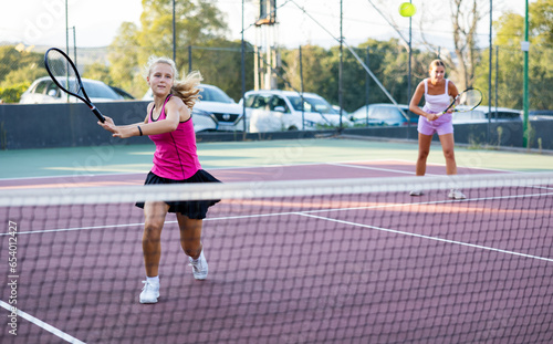 Sporty woman plays tennis. View through tennis net © JackF