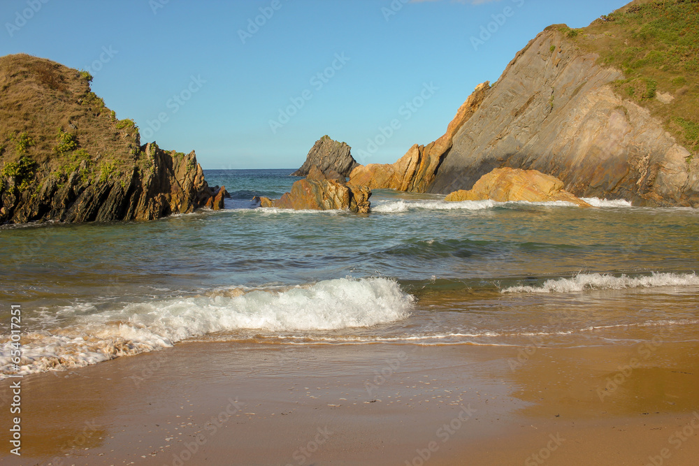 waves in a beach with rocks