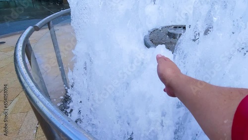 Hand passing through gushing water fountain. photo