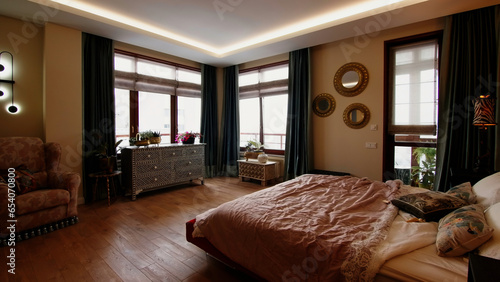 Modern luxury bedroom interior. Creative. Cozy and comfortable apartment spacious bedroom with many windows.