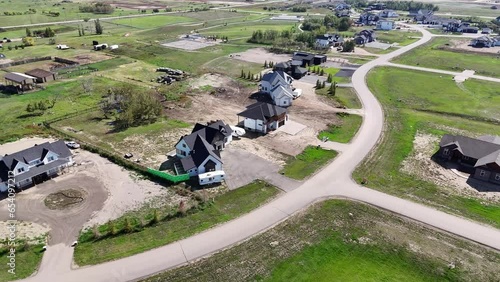 Aerial footage of Edgemont Estates, Saskatoon, SK, showcasing its upscale homes, manicured landscapes, and community design. A pristine suburban enclave, perfect for real estate showcases. photo