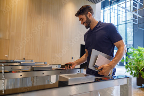 Happy successful businessman or entrepreneur enters office going through security gates doorway