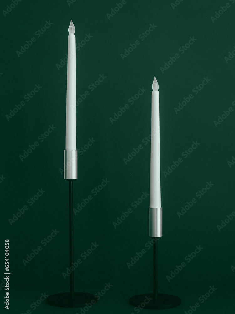 Two beautiful electronic candles on a green background. Two beautiful electronic candles on a green background.