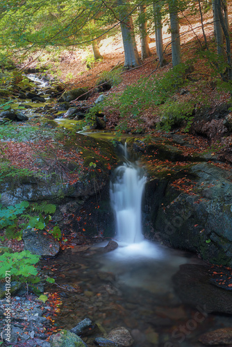 Small waterfall on Stredni Opava river in the middle of early autumn forest in the Jeseniky mountains in Czech republik.