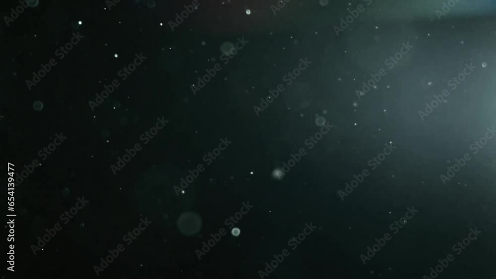 Colorful lens flare bokeh moving particles. Colored abstract blurred lights dust background.