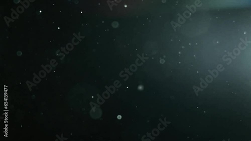 Colorful lens flare bokeh moving particles. Colored abstract blurred lights dust background.
