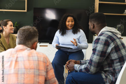 Принти на полотні Diverse group of friends and female therapist with tablet in group therapy sessi