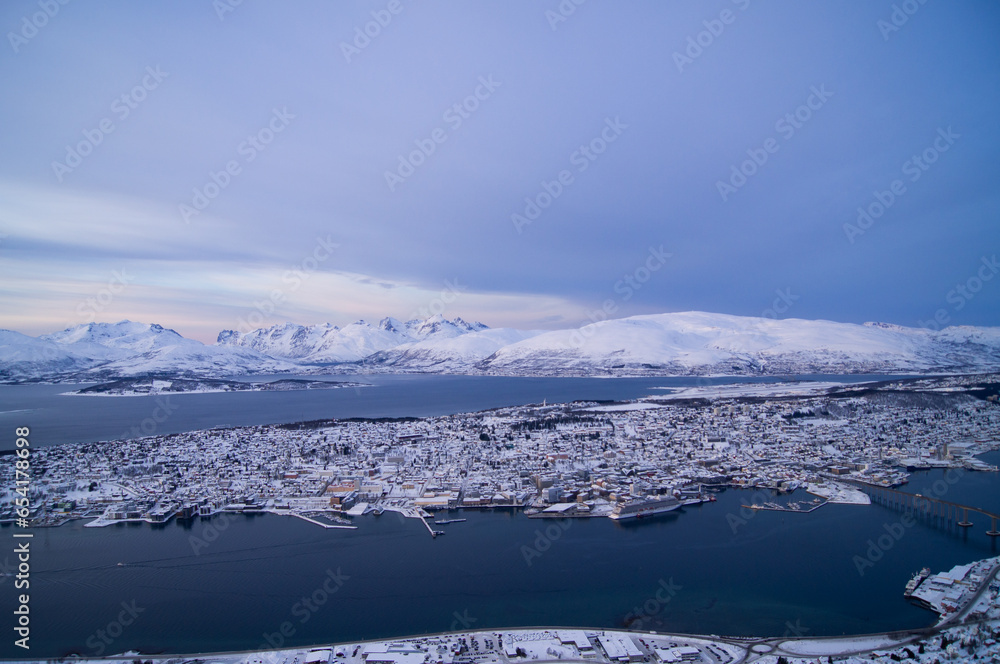 Obraz premium Evening view from the top of the mountain in Tromso, Norway. Polar circle, in winter. Fjord, polar sea. Dark evening. Breath-taking view. Town, city from the top, drone view, on island. Polar night