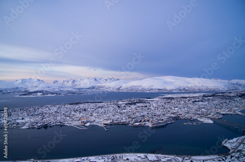 Evening view from the top of the mountain in Tromso, Norway. Polar circle, in winter. Fjord, polar sea. Dark evening. Breath-taking view. Town, city from the top, drone view, on island. Polar night