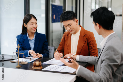 Business people compassionately holding hands and discussing contract papers with laptop and tabletat office room.. photo