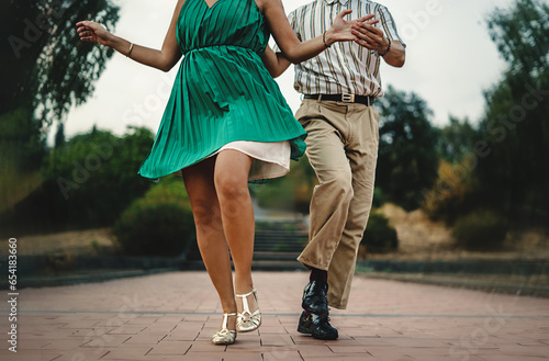 Swing Dance Steps in Motion - Close-up of dancers' feet and attire in swing dance outdoors. Distinctive vintage style details photo