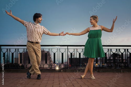 Swing Dancers on Terrace with Open Sky: Couple dancing in profile on a terrace, vast backdrop ideal for copy space. photo