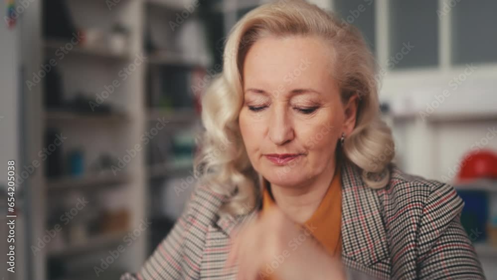 Elegant female architect in her 50s working in office, thinking about project Elegant female architect in her 50s working in office, thinking about project