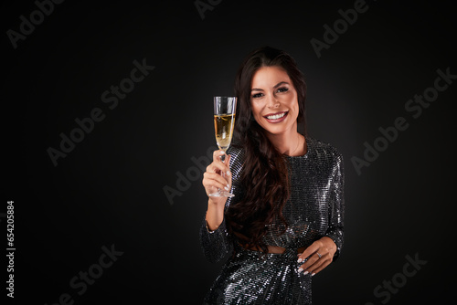 Portrait of an elegantly dressed woman, holding a glass of champagne.