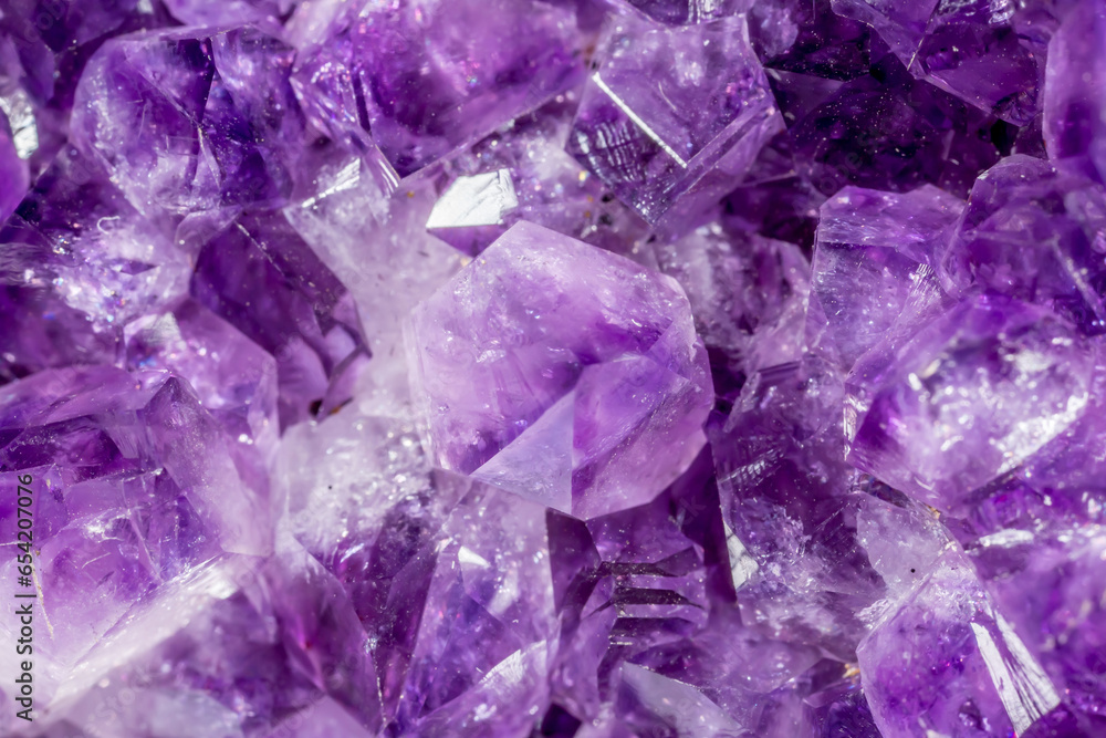 Amethyst purple crystals. Gems. Mineral crystals in the natural environment. Texture of precious and semiprecious stones. Seamless background with copy space colored shiny surface of precious stones. Amethyst purple crystals. Gems. Mineral crystals in the natural environment. Texture of precious and semiprecious stones. Seamless background with copy space colored shiny surface of precious stones.