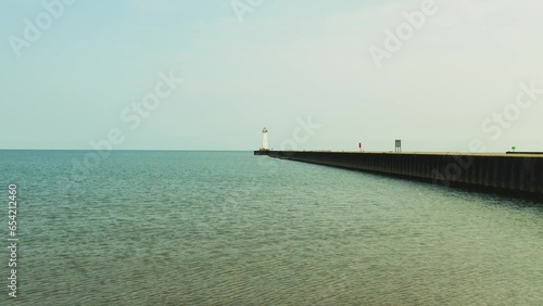 Drone shot push in over the water toward the small light house at Sodus point New York vacation spot at the tip of land on the banks of Lake Ontario. photo