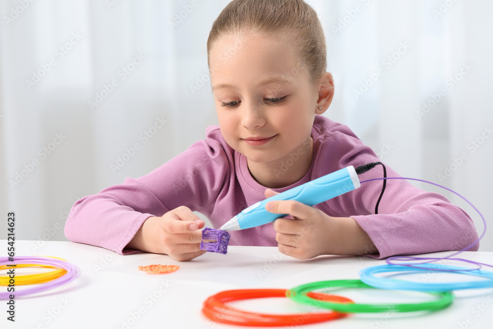 Girl drawing with stylish 3D pen at white table indoors Girl drawing with stylish 3D pen at white table indoors