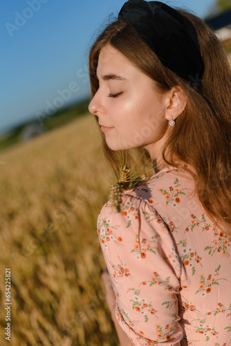 A woman in a beautiful dress in a rye field in the morning